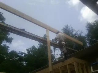 Carpenter setting a ridge beam over a new addition frame — Ice Dam Removal by Roofing Brothers in Ephrata