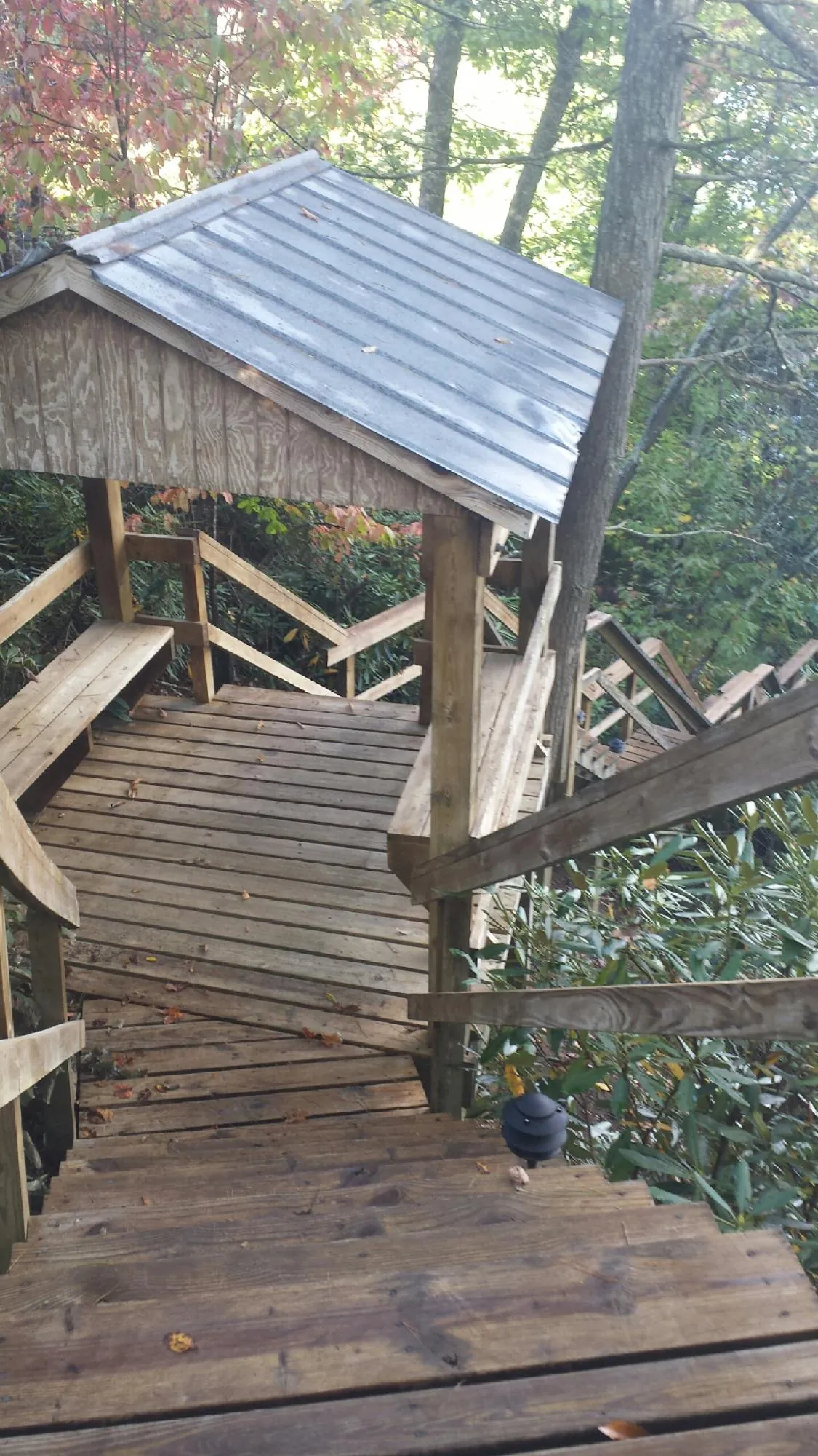 Metal roofed shelter over wooden steps on a wooded walkway — Skylight Repair & Installation work by our crew in Ephrata